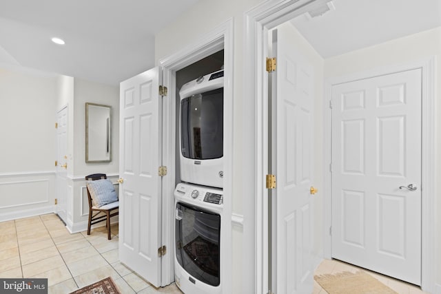 washroom featuring light tile patterned floors and stacked washer / drying machine