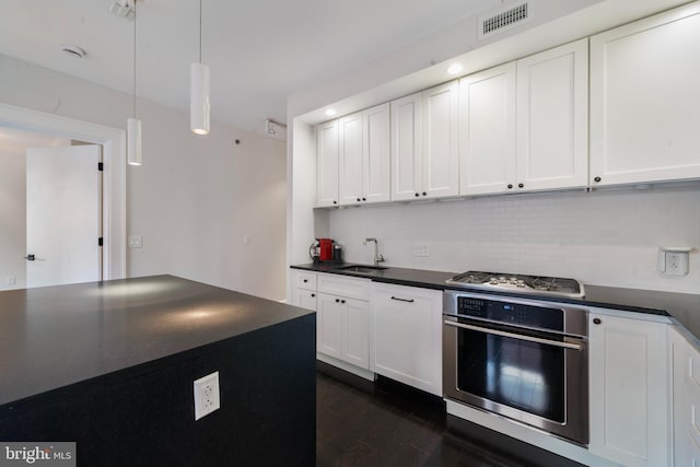 kitchen featuring wall oven, backsplash, sink, decorative light fixtures, and white cabinets