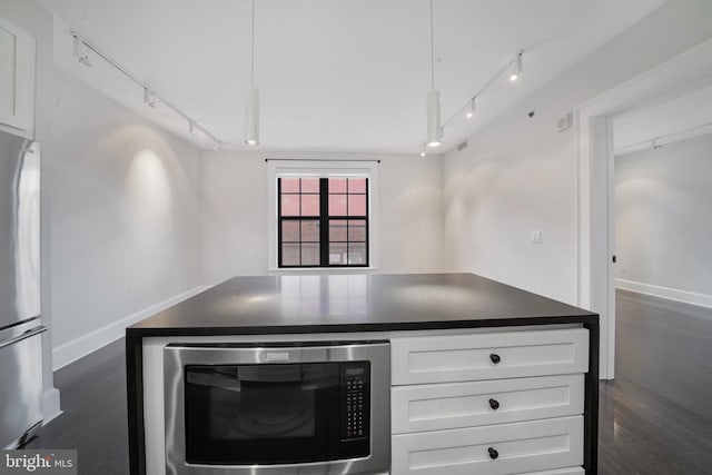 kitchen featuring dark hardwood / wood-style flooring, white cabinetry, built in microwave, and stainless steel refrigerator