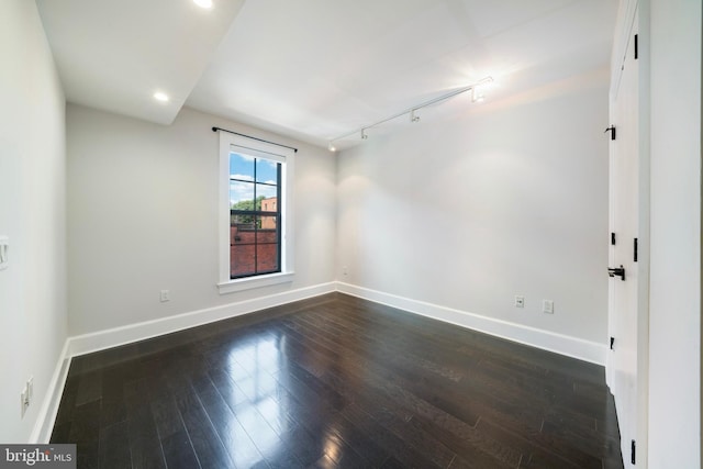 unfurnished room featuring dark hardwood / wood-style floors and track lighting