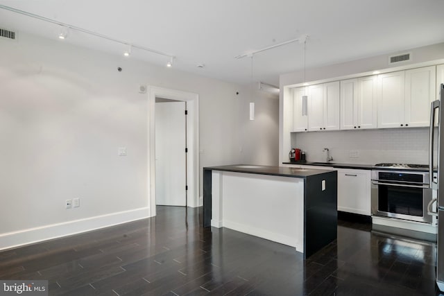 kitchen featuring stainless steel oven, tasteful backsplash, a kitchen island, dark hardwood / wood-style flooring, and white cabinetry