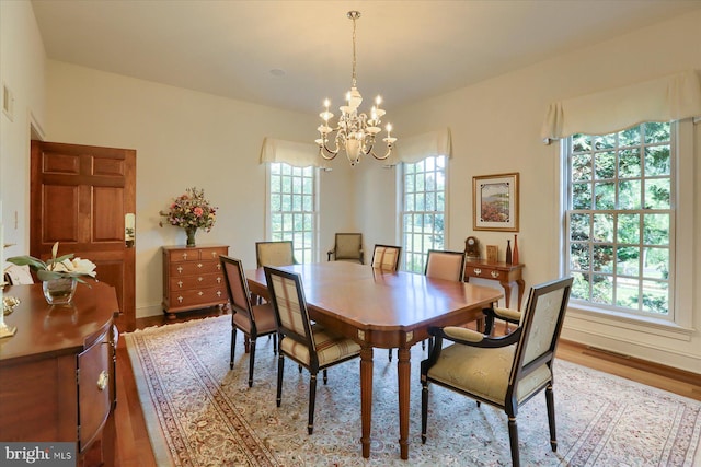 dining space featuring light hardwood / wood-style floors and an inviting chandelier