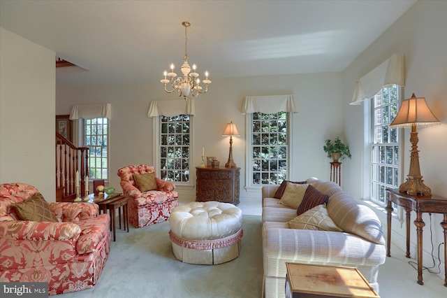 living room with a wealth of natural light, a chandelier, and light carpet