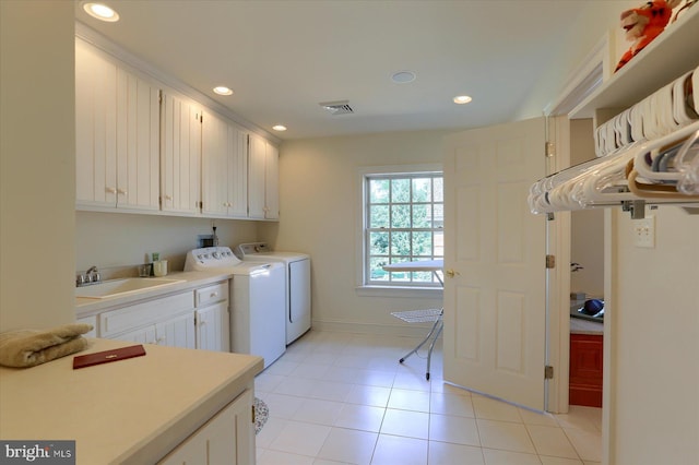 laundry area featuring light tile patterned flooring, cabinets, independent washer and dryer, and sink