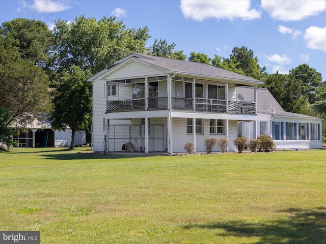 rear view of property featuring a yard and a sunroom