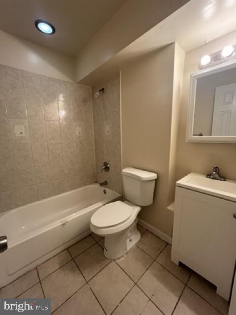 full bathroom with toilet, tile patterned flooring, vanity, and tiled shower / bath