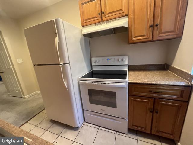 kitchen featuring light tile patterned floors and white appliances