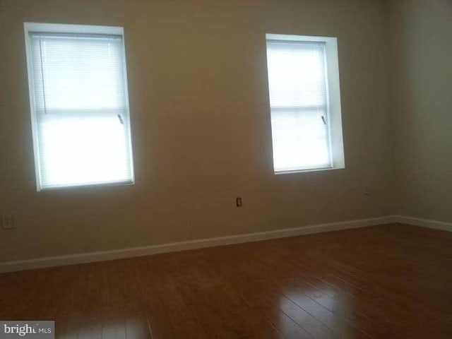 spare room featuring dark wood-type flooring