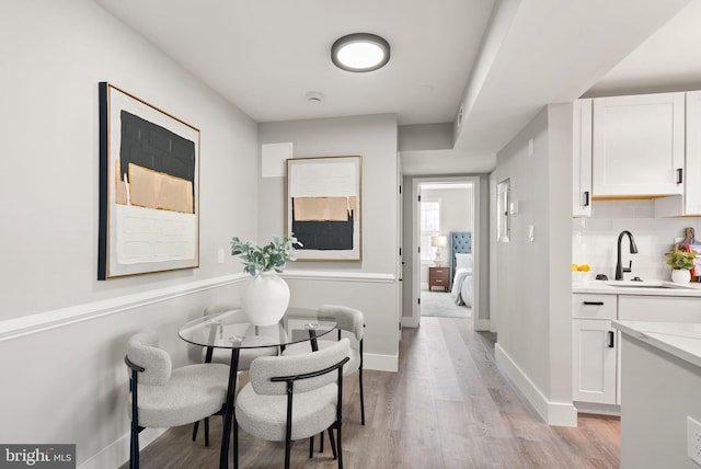 dining space with light hardwood / wood-style floors and sink