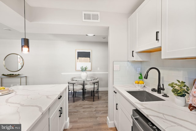 kitchen with white cabinets, sink, and hanging light fixtures