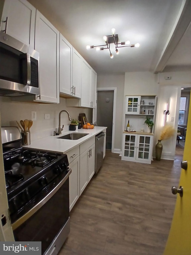 kitchen with white cabinetry, sink, stainless steel appliances, dark hardwood / wood-style flooring, and a chandelier