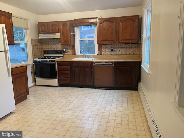 kitchen featuring dishwasher, sink, tasteful backsplash, stove, and white fridge