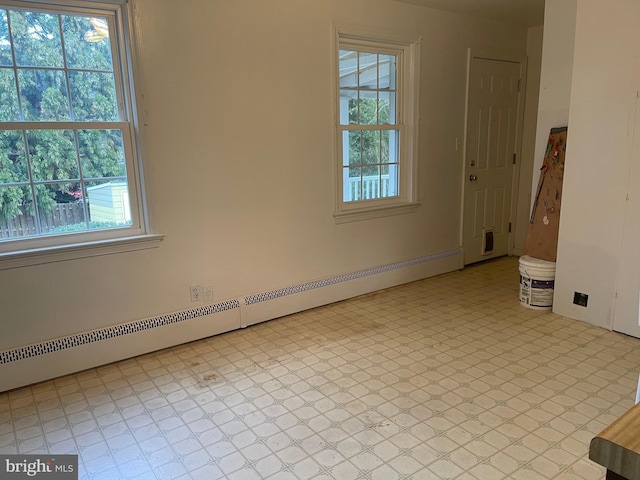 spare room featuring a wealth of natural light and a baseboard heating unit