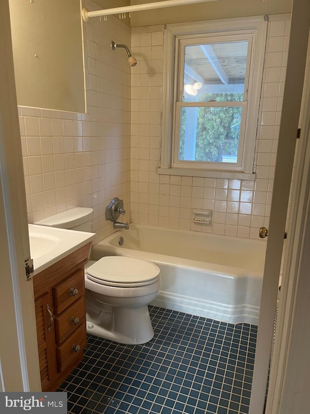 full bathroom with tile patterned floors, vanity, tile walls, toilet, and tiled shower / bath