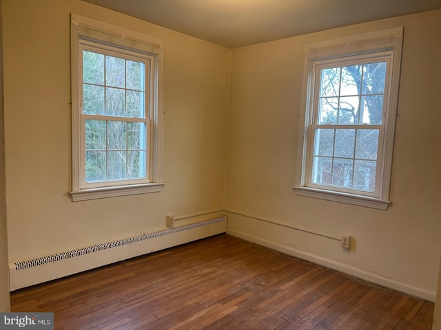 unfurnished room with hardwood / wood-style floors and baseboard heating