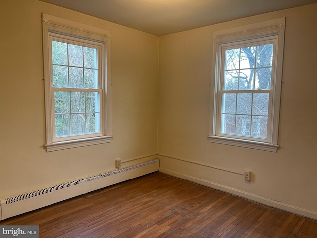 unfurnished room with hardwood / wood-style floors and a baseboard radiator