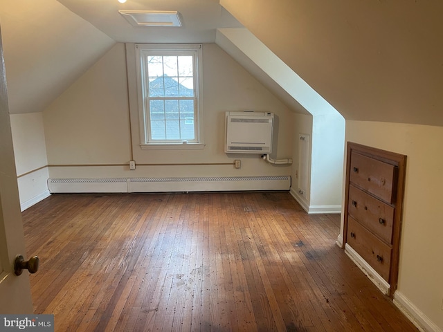 bonus room featuring dark hardwood / wood-style flooring, heating unit, vaulted ceiling, a baseboard heating unit, and an AC wall unit