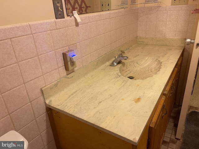 bathroom featuring decorative backsplash, vanity, toilet, and tile walls