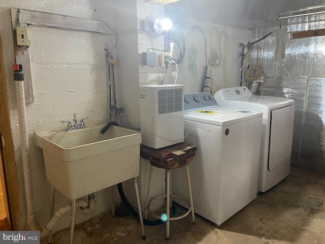 clothes washing area with sink and washing machine and clothes dryer