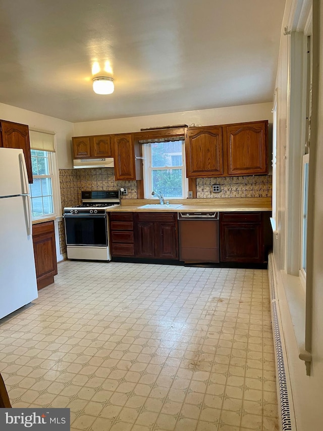 kitchen with backsplash, sink, and white appliances