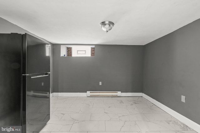 basement featuring black refrigerator and baseboard heating