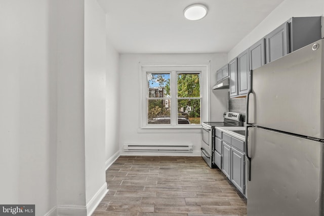 kitchen with gray cabinetry, light hardwood / wood-style flooring, appliances with stainless steel finishes, and a baseboard heating unit