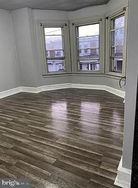 unfurnished room featuring french doors and dark wood-type flooring