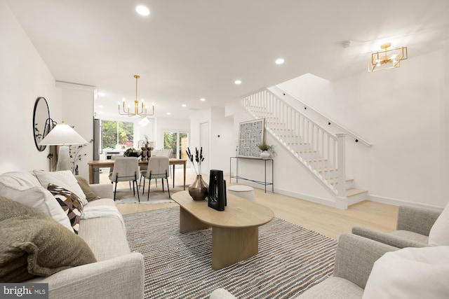 living room with light hardwood / wood-style floors and a notable chandelier