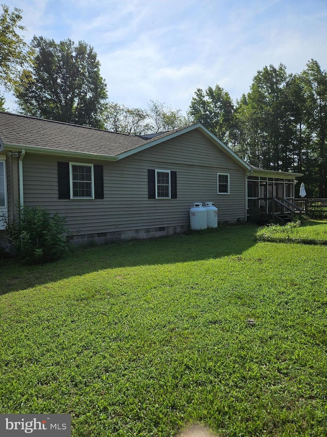 view of home's exterior with a lawn and a sunroom