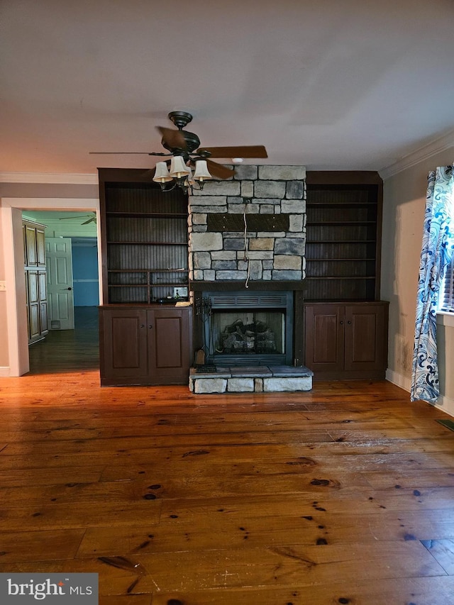 unfurnished living room featuring crown molding, dark hardwood / wood-style floors, ceiling fan, and a fireplace