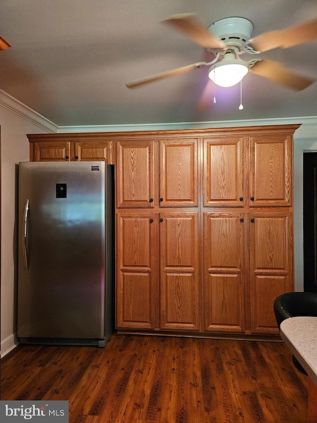 kitchen featuring dark hardwood / wood-style flooring, crown molding, stainless steel refrigerator, and ceiling fan