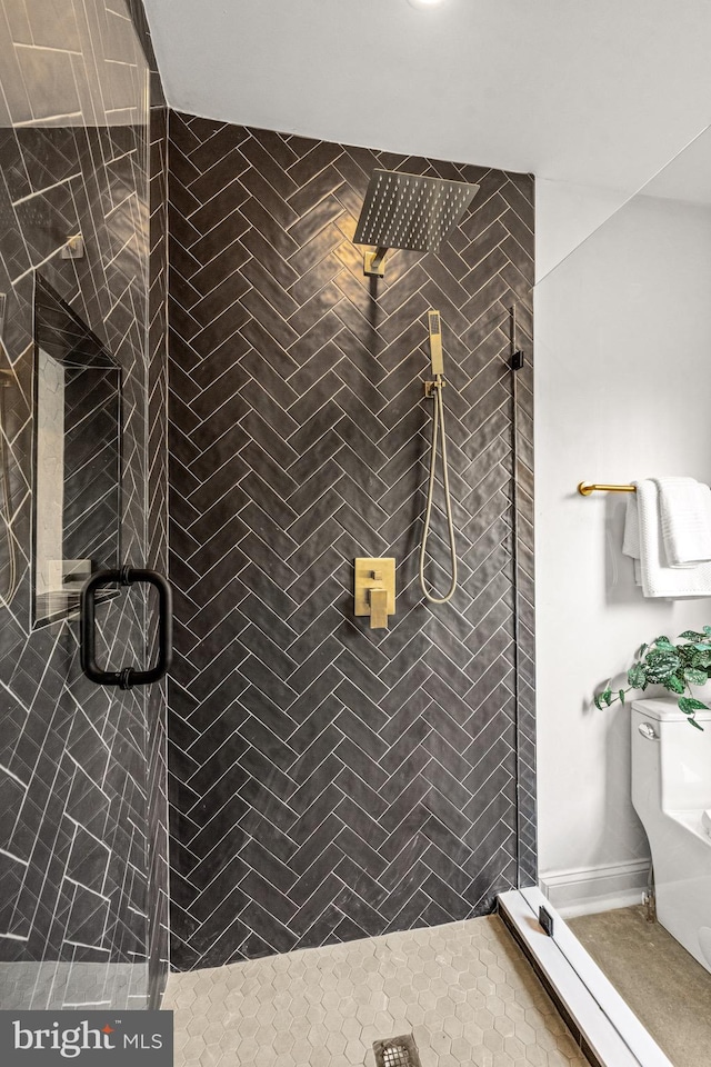 bathroom with a shower with shower door, tile patterned flooring, and toilet