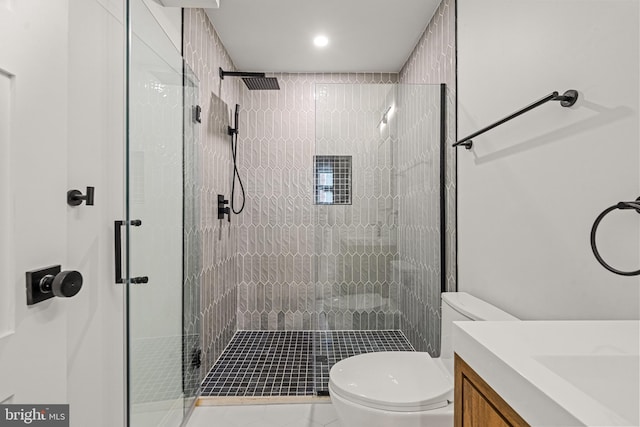 bathroom featuring tile patterned flooring, a shower with shower door, toilet, and vanity