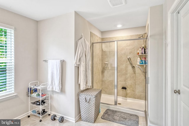 bathroom with tile patterned floors, plenty of natural light, and a shower with shower door