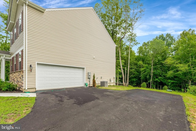 view of side of property featuring a garage and central AC