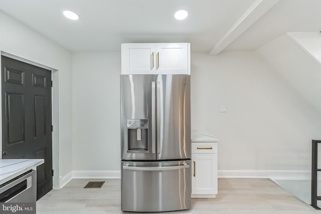 kitchen with light stone countertops, white cabinets, stainless steel appliances, and light hardwood / wood-style floors