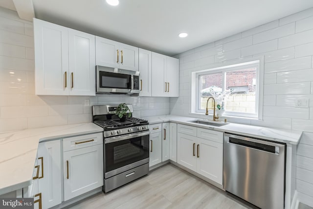 kitchen with white cabinets, sink, and appliances with stainless steel finishes