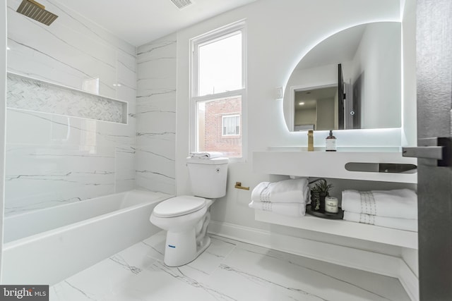 bathroom with tiled shower / bath and toilet