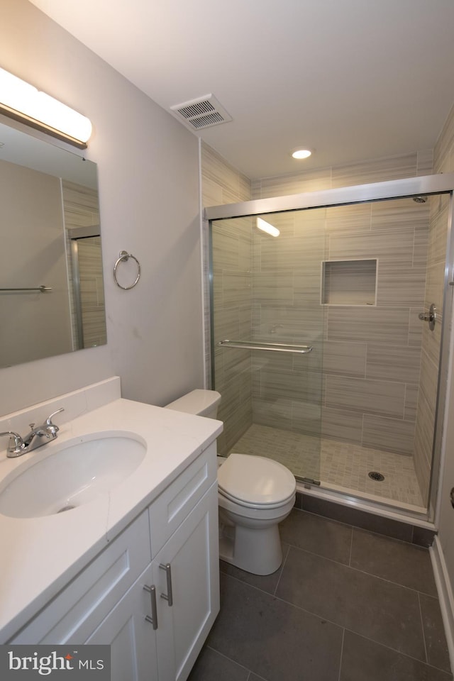 bathroom with vanity, toilet, an enclosed shower, and tile patterned flooring