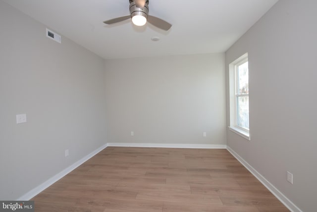 spare room featuring ceiling fan, a wealth of natural light, and light hardwood / wood-style floors