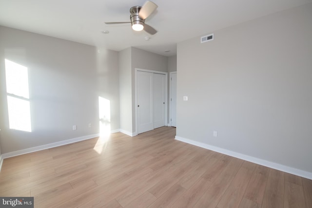 empty room with ceiling fan and light hardwood / wood-style flooring