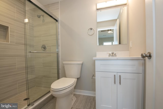 bathroom with vanity, a shower with door, and toilet