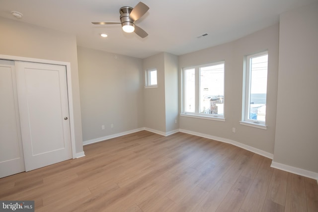 unfurnished bedroom featuring light hardwood / wood-style flooring, a closet, and ceiling fan