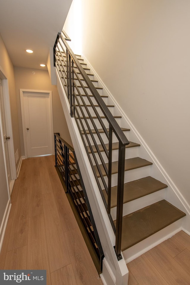 staircase with hardwood / wood-style floors