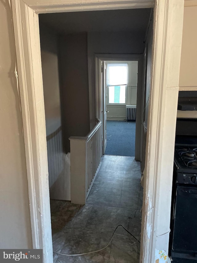 corridor with radiator and dark carpet