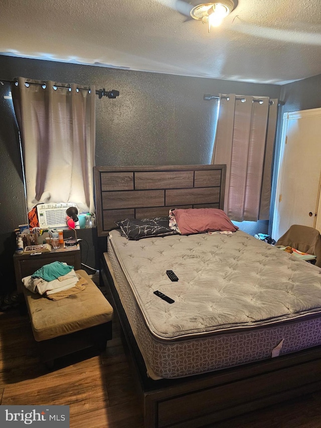 bedroom with wood-type flooring and a textured ceiling