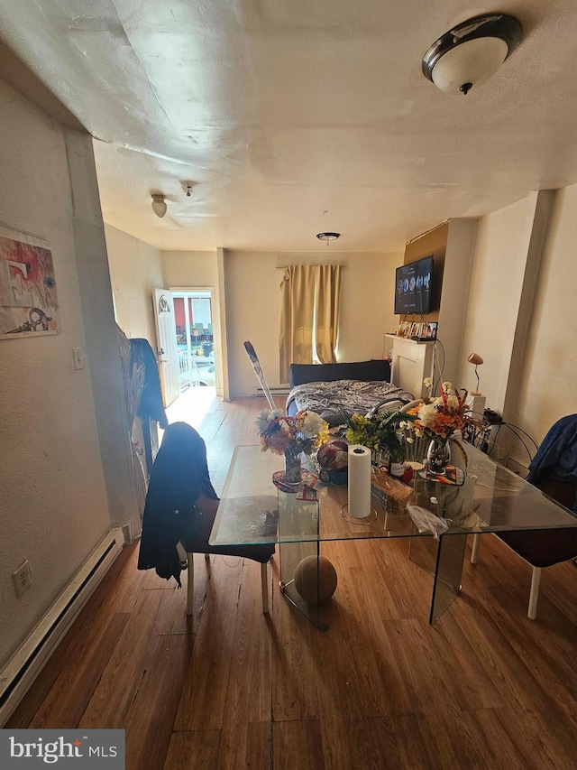 dining area with hardwood / wood-style flooring and a baseboard heating unit