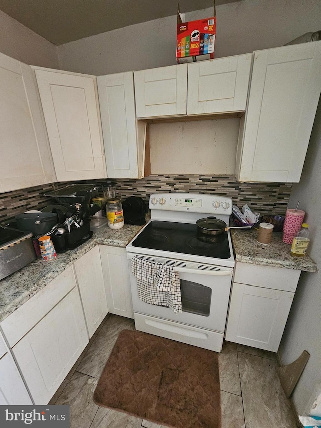 kitchen featuring white electric range, tasteful backsplash, and white cabinetry