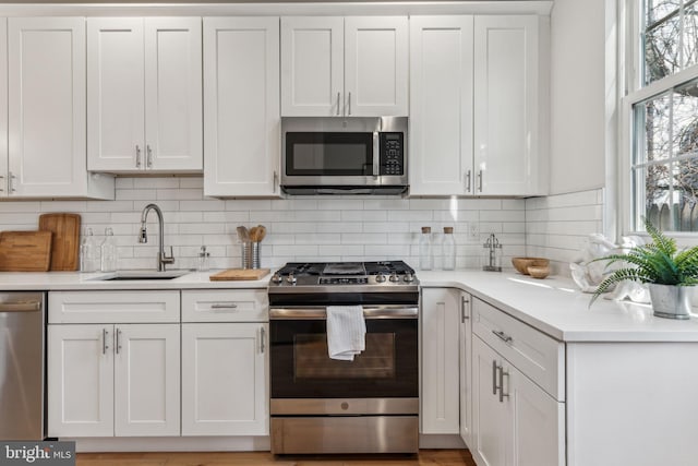 kitchen featuring appliances with stainless steel finishes, white cabinetry, and tasteful backsplash