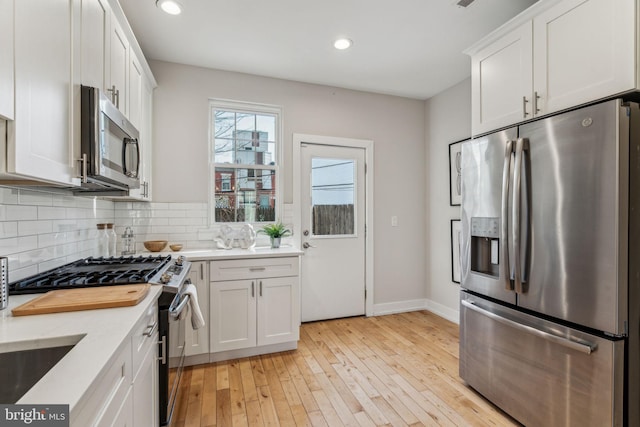 kitchen featuring white cabinetry, light hardwood / wood-style flooring, and stainless steel appliances